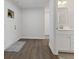 Clean entryway featuring wood-look floors, white walls and trim, and a clear view of the adjacent bathroom at 7051 E Bean Blossom Dr, Camby, IN 46113