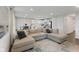 Spacious living room with a large sectional sofa, hardwood floors, and a modern, open-concept design leading to the kitchen at 7051 E Bean Blossom Dr, Camby, IN 46113
