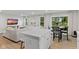 Open-concept living area with kitchen island, dining area, and living room with bright, natural light at 7051 E Bean Blossom Dr, Camby, IN 46113