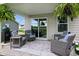 Relaxing covered patio with wicker seating, stylish rug, and sliding glass door for seamless indoor-outdoor living at 7051 E Bean Blossom Dr, Camby, IN 46113