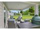 Spacious covered patio with comfortable seating, picturesque backyard views, and an outdoor cooking area at 7051 E Bean Blossom Dr, Camby, IN 46113