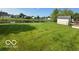 Lush backyard with a storage shed and view of a pond adding to the property's charm at 7549 Stockard St, Indianapolis, IN 46239