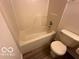 Bathroom featuring a tub with shower and standard toilet at 7549 Stockard St, Indianapolis, IN 46239