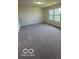 Spacious bedroom with a large window and neutral-colored carpet, great for relaxation at 7549 Stockard St, Indianapolis, IN 46239