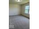 Bright bedroom featuring a large window, neutral walls, and carpeted flooring at 7549 Stockard St, Indianapolis, IN 46239