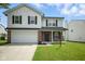 Charming two-story home featuring a well-maintained lawn, attached garage, and inviting front entrance at 7549 Stockard St, Indianapolis, IN 46239