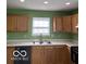 Kitchen featuring oak cabinets and a stainless steel sink underneath a window at 7549 Stockard St, Indianapolis, IN 46239