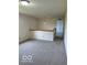 Cozy living room with neutral carpet, half wall, and hanging light fixture at 7549 Stockard St, Indianapolis, IN 46239