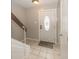 Bright foyer area with neutral tile flooring and a staircase leading to the upper level at 7940 Benjamin Dr, Lawrence, IN 46226