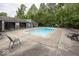Community swimming pool with plenty of lounge chairs surrounded by mature trees, perfect for summer relaxation at 7940 Benjamin Dr, Lawrence, IN 46226