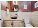 Half bath with decorative mirror, pedestal sink, granite countertop, and tiled lower half at 8301 Reef Ct, Indianapolis, IN 46236