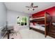 A bedroom with a bunk bed, a desk, and a large window providing lots of light at 8301 Reef Ct, Indianapolis, IN 46236