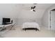 Cozy attic bedroom with a desk, ceiling fan, carpet and neutral paint at 8301 Reef Ct, Indianapolis, IN 46236