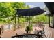 Back deck with black umbrella, outdoor seating, and beautiful views of the water and mature trees at 8301 Reef Ct, Indianapolis, IN 46236