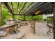 Outdoor kitchen with grill, bar, and ample counter space under a pergola at 8301 Reef Ct, Indianapolis, IN 46236
