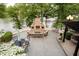 Inviting patio with a stone fireplace, comfortable seating, and scenic lake views, perfect for outdoor living at 8301 Reef Ct, Indianapolis, IN 46236