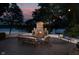 Stunning outdoor patio with a stone fireplace and comfortable seating overlooking a serene lake at twilight at 8301 Reef Ct, Indianapolis, IN 46236
