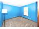 Cozy bedroom with carpet flooring, window and bright blue accent wall at 9010 Deer Run Dr, Indianapolis, IN 46256