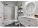 Well-lit bathroom with a shower and tub combo, a white vanity, and an oval mirror at 941 N Beville Ave, Indianapolis, IN 46201