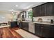 An open kitchen with stainless steel appliances, dark cabinets, and a view into an adjacent living area at 941 N Beville Ave, Indianapolis, IN 46201