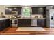 Well-lit kitchen featuring stainless steel appliances, dark cabinets, and light granite countertops at 941 N Beville Ave, Indianapolis, IN 46201