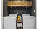 Laundry room featuring a washer, dryer, dark walls, and shelves with storage baskets at 941 N Beville Ave, Indianapolis, IN 46201
