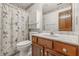 Charming bathroom with a wood vanity and leaf-patterned wallpaper at 959 Harvest Ridge Dr, Avon, IN 46123