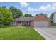 Charming brick home with a manicured lawn and a two-car attached garage beneath a sunny sky at 959 Harvest Ridge Dr, Avon, IN 46123