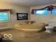 Relaxing bathroom featuring a corner tub, tiled surround, and natural light at 9701 Hamilton Hills Ln, Fishers, IN 46038
