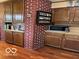 Spacious kitchen featuring wood cabinets, ample counter space, and an exposed brick pillar at 9701 Hamilton Hills Ln, Fishers, IN 46038