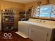 Functional laundry room with shelving and a side by side washer and dryer set at 9701 Hamilton Hills Ln, Fishers, IN 46038