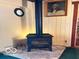 Cozy living room featuring a wood burning stove, paneled walls, and a picture on the wall at 9701 Hamilton Hills Ln, Fishers, IN 46038