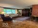 Comfortable living room with large windows, hardwood floors, and a brick fireplace at 9701 Hamilton Hills Ln, Fishers, IN 46038