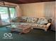 Comfortable living room featuring a couch, coffee table, paneled walls, and natural light at 9701 Hamilton Hills Ln, Fishers, IN 46038
