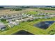Scenic aerial view of a residential area with a pond and green lawns, showcasing community living at 104 Perlican Dr, Cicero, IN 46034