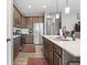 Well-lit kitchen featuring stainless steel appliances, wooden cabinets, and an island with sink and light stone countertop at 104 Perlican Dr, Cicero, IN 46034