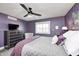 Well-lit bedroom with purple walls, window, and dresser at 10479 Dusty Rose Dr, Zionsville, IN 46077