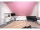 Cozy bedroom featuring a desk and sloped ceilings with a pink accent wall at 10479 Dusty Rose Dr, Zionsville, IN 46077