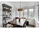 Cozy dining area with large windows, modern chandelier, and a dark wood table with chairs at 10479 Dusty Rose Dr, Zionsville, IN 46077
