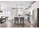 Elegant white kitchen with stainless steel appliances, a center island, and stylish pendant lighting at 10479 Dusty Rose Dr, Zionsville, IN 46077