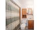 Functional bathroom with a neutral color scheme, wood vanity, and patterned shower curtain at 105 Golf Club Rd, Anderson, IN 46011