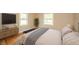 Relaxing bedroom with wood floors, natural light, and a sleek TV mounted on the wall at 105 Golf Club Rd, Anderson, IN 46011