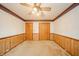 Simple bedroom featuring wood paneling, neutral carpet, and ample closet space at 105 Golf Club Rd, Anderson, IN 46011