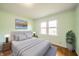 Staged bedroom with a large window, a queen bed and matching lamps at 105 Golf Club Rd, Anderson, IN 46011