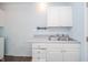 Kitchenette featuring white cabinets, laminate countertops, and a stainless steel sink at 105 Golf Club Rd, Anderson, IN 46011