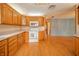 Bright kitchen with white appliances, wood cabinetry, and view of the living area at 105 Golf Club Rd, Anderson, IN 46011