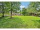 Beautiful green backyard featuring mature trees and a partial view of the home's exterior and pool at 1121 N Cambridge Ct, Greenfield, IN 46140