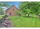 Spacious backyard featuring a mix of green lawn, trees, and a portion of the home's exterior at 1121 N Cambridge Ct, Greenfield, IN 46140