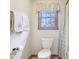 Cozy bathroom with decorative towels and curtain, toilet, and window providing natural light for a tranquil and relaxing space at 1121 N Cambridge Ct, Greenfield, IN 46140