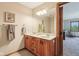 Bright bathroom featuring a double sink vanity with wooden cabinets, a large mirror, and access to an adjacent bedroom at 1121 N Cambridge Ct, Greenfield, IN 46140